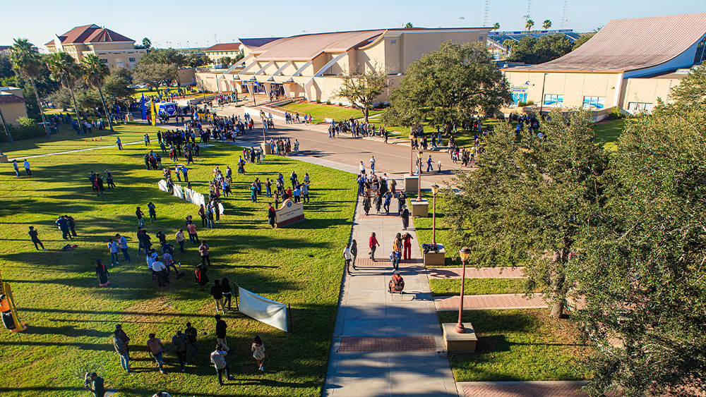 An overview perspective of the front lawn of the College of Engineering with groups of people scattered across the lawn.