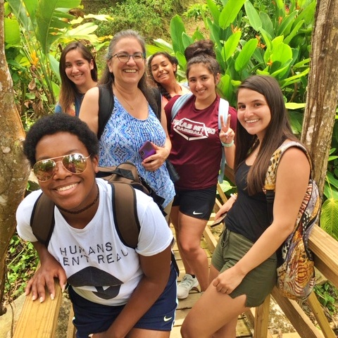 6 smiling biology students posing in a rain forest