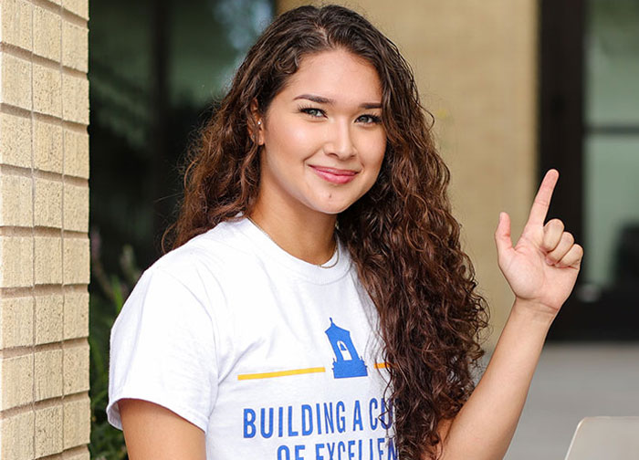 Student posing with the J-Sign