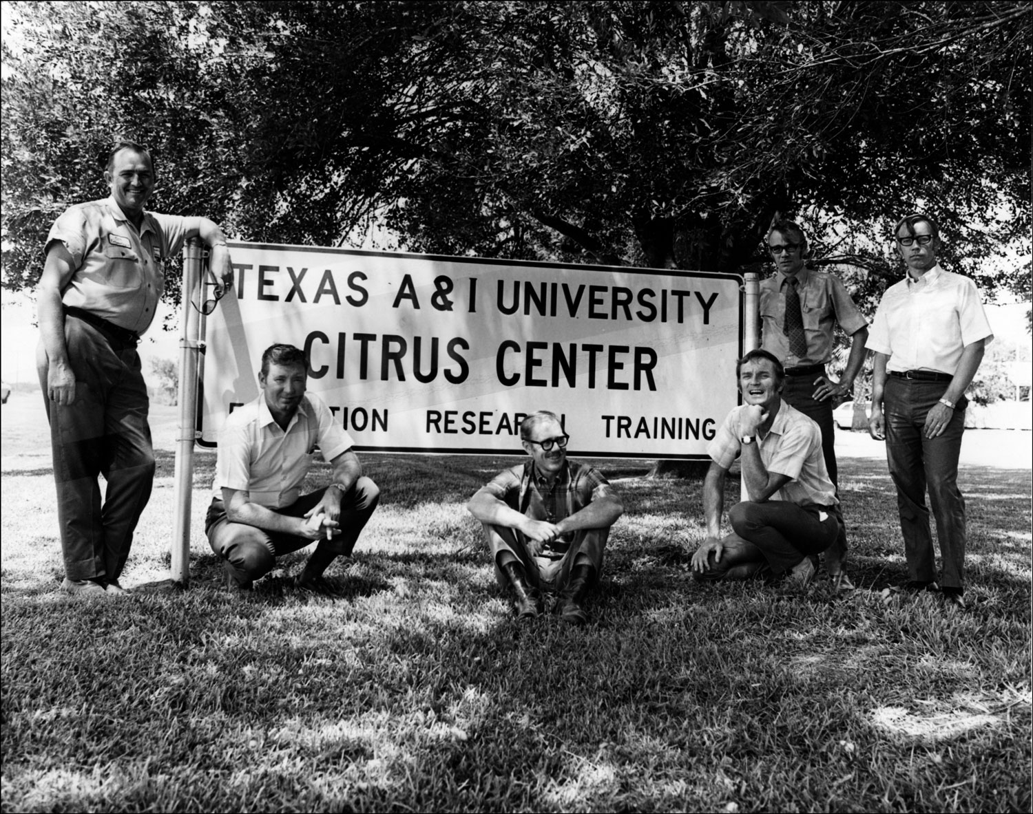 Faculty pose in front of the Citrus Center sign