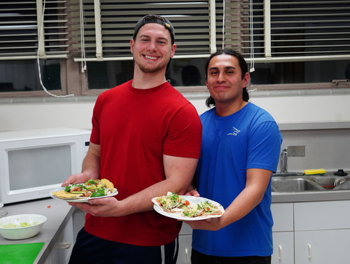 Two Male students holding plates of food