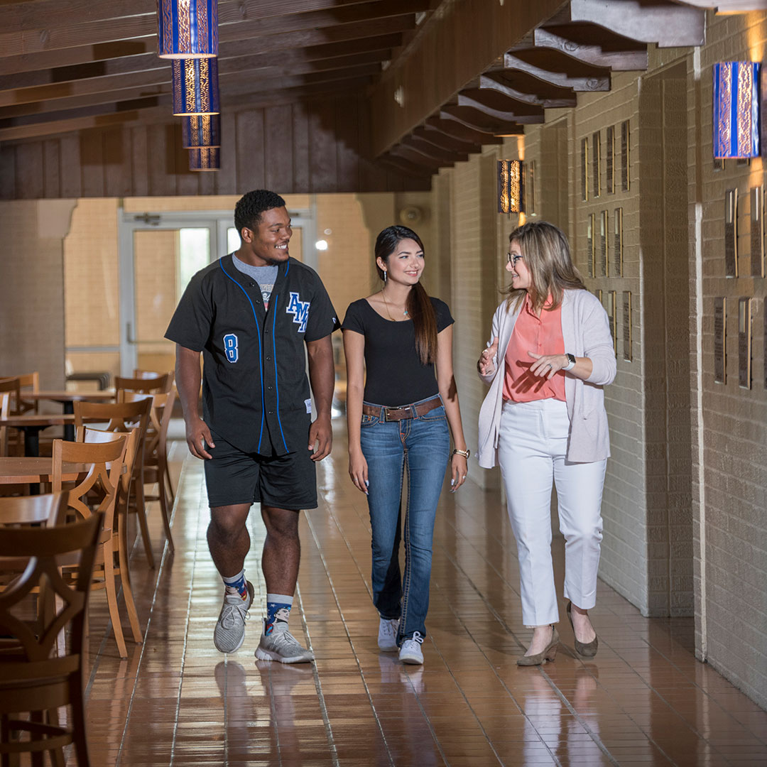 Two A&M Kingsville students walking with a representative from Enrollment Management