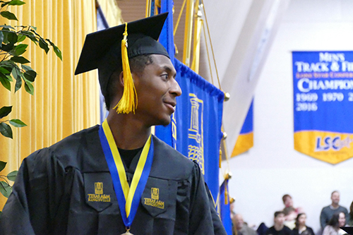 Student walking the stage during graduation.