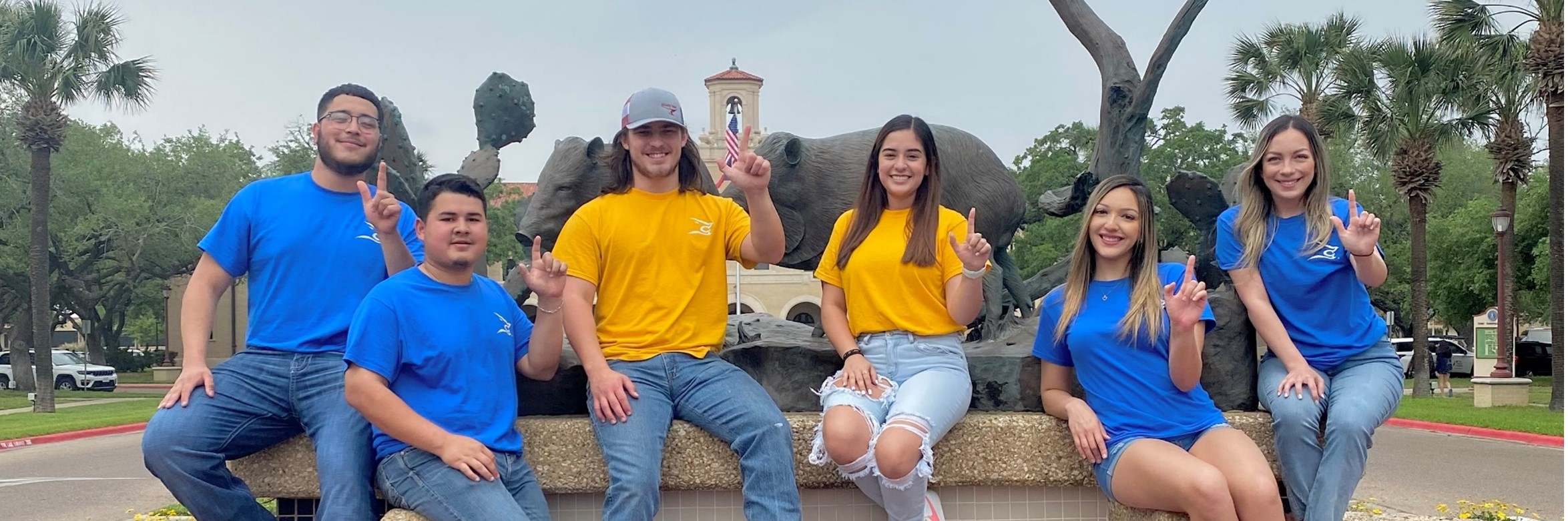 HEART Project mentors standing in front of TAMUK javelina statues with j's up.
