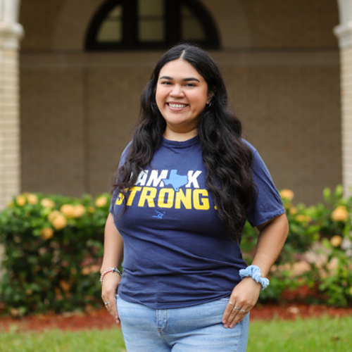 Transfer student standing in front of college hall