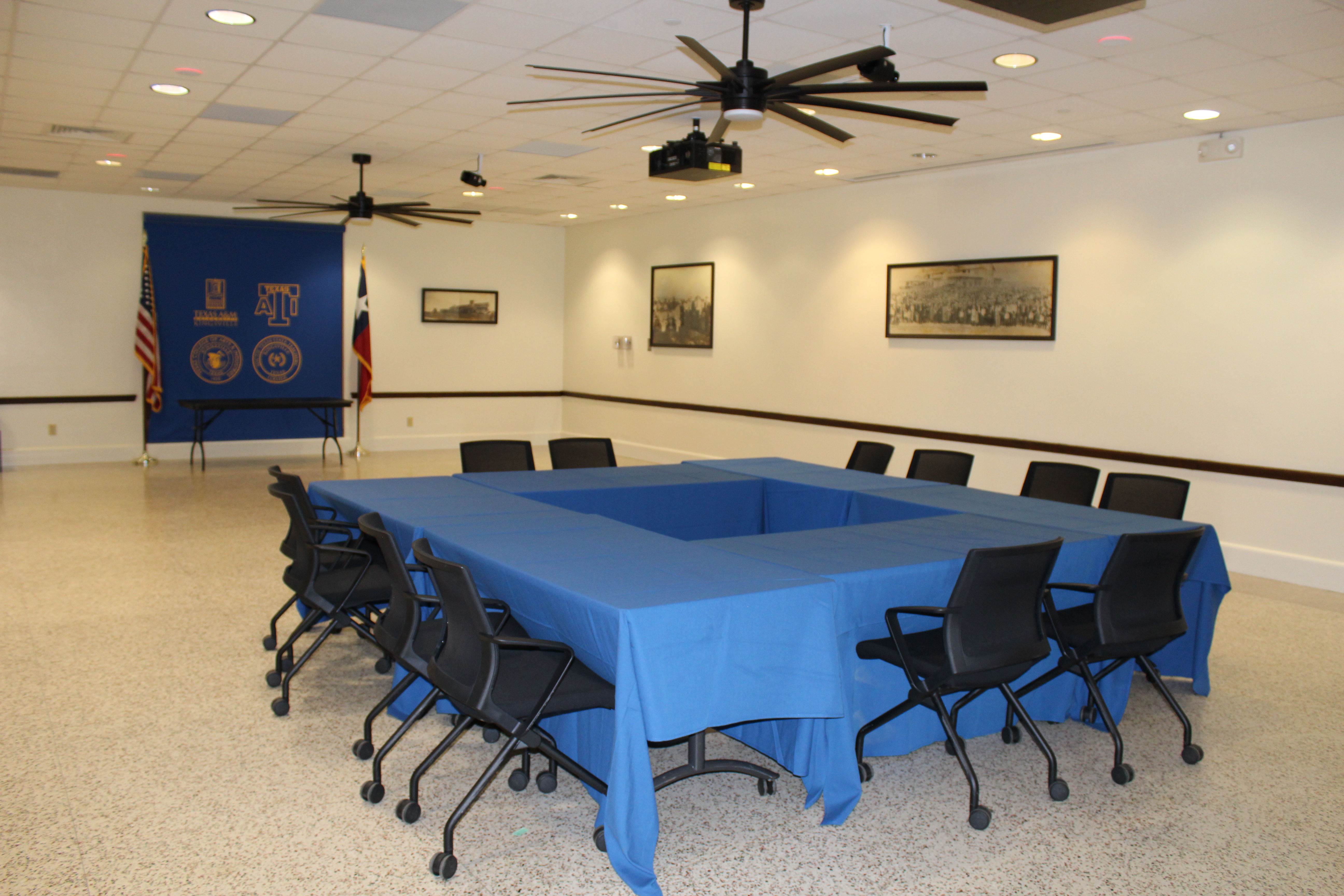 The Founders Room Dining Room, including tables setup in a square with blue fabric table covers.