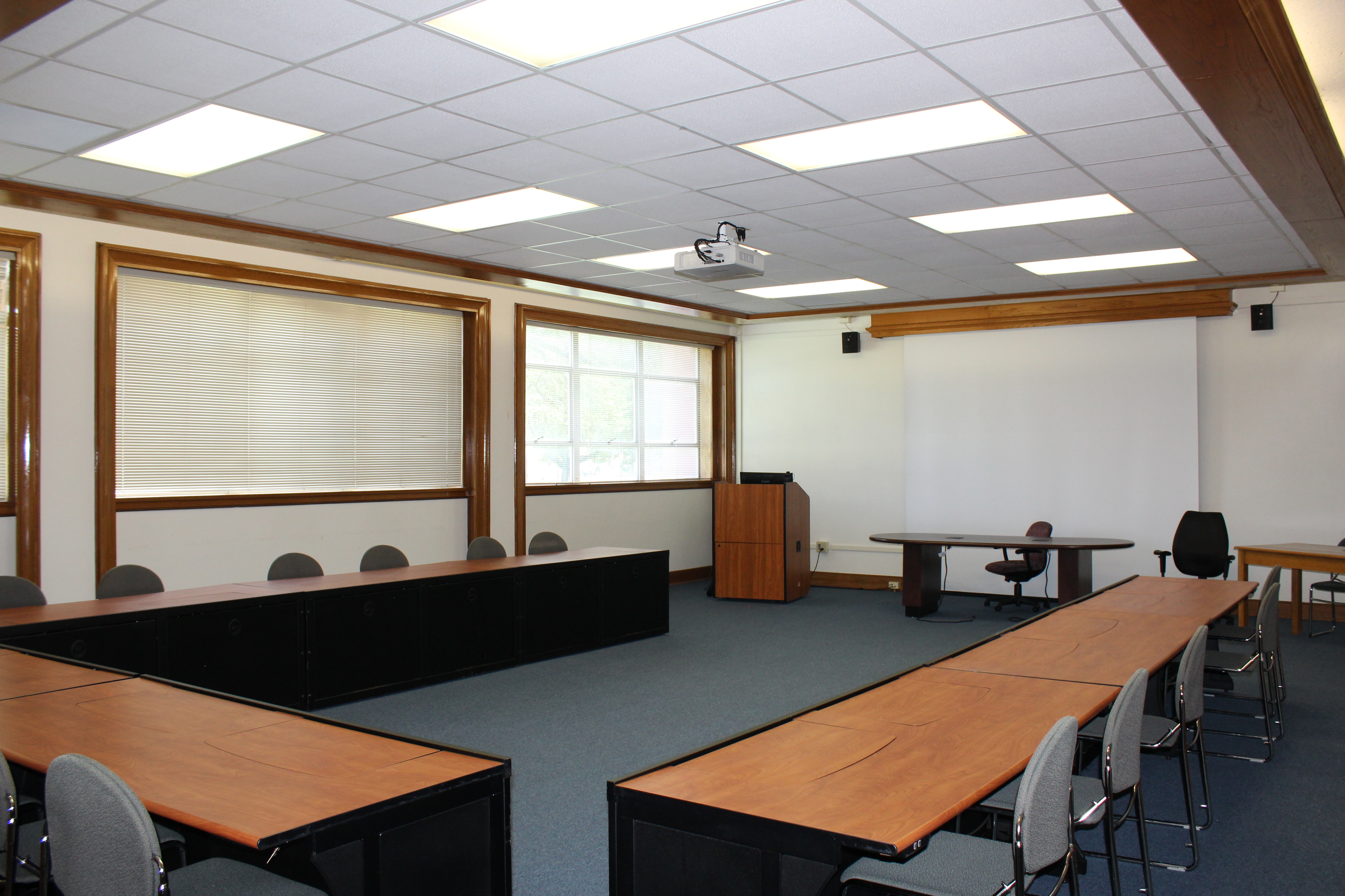 A large, U-shape oriented conference room with blue carpets.