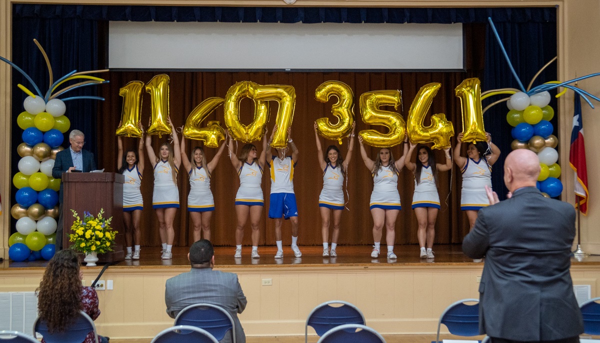 Javelina cheer team members help unveil the final amount.
