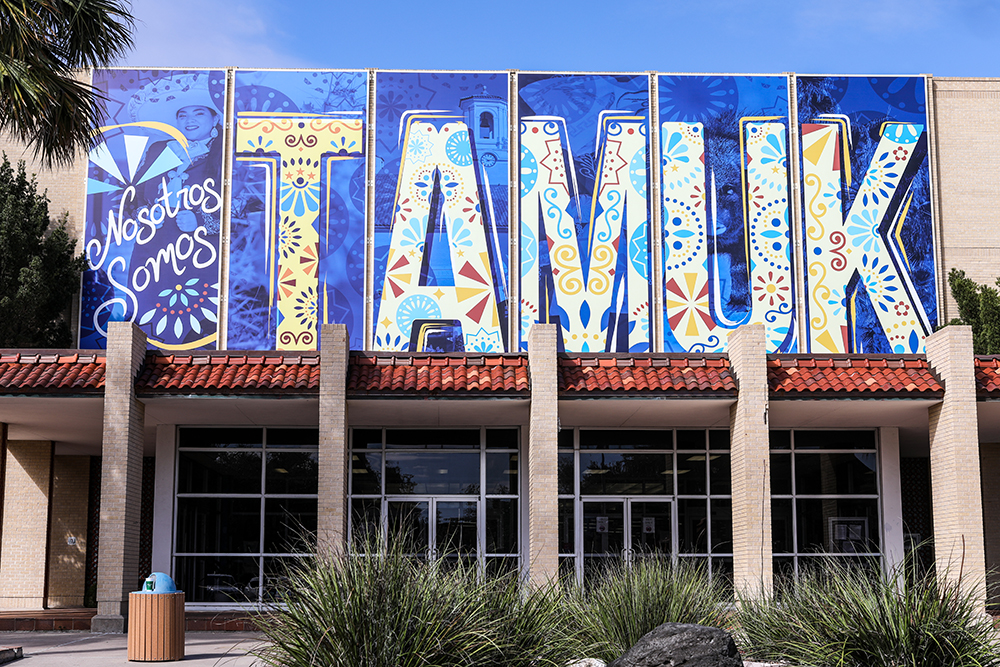 Photo of the large banners outside of the Jernigan Library that spell out TAMUK.