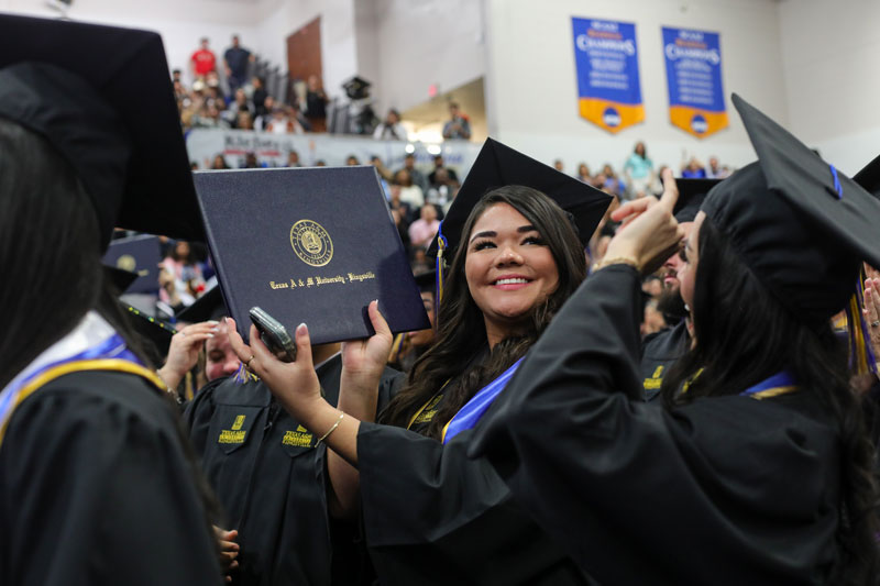 Texas A&M University-Kingsville graduate hold up diploma
