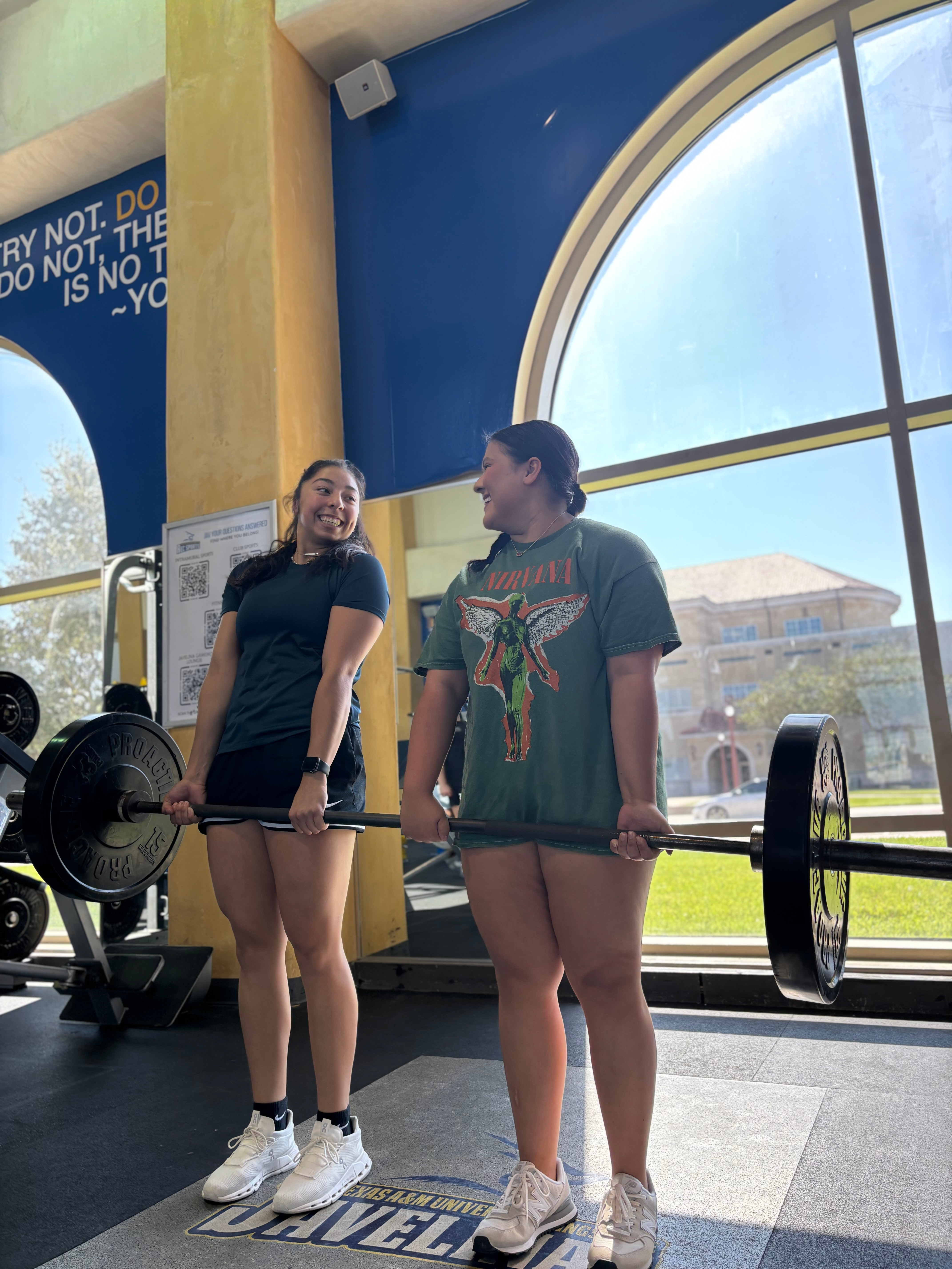 Student working with a trainer on proper squat form